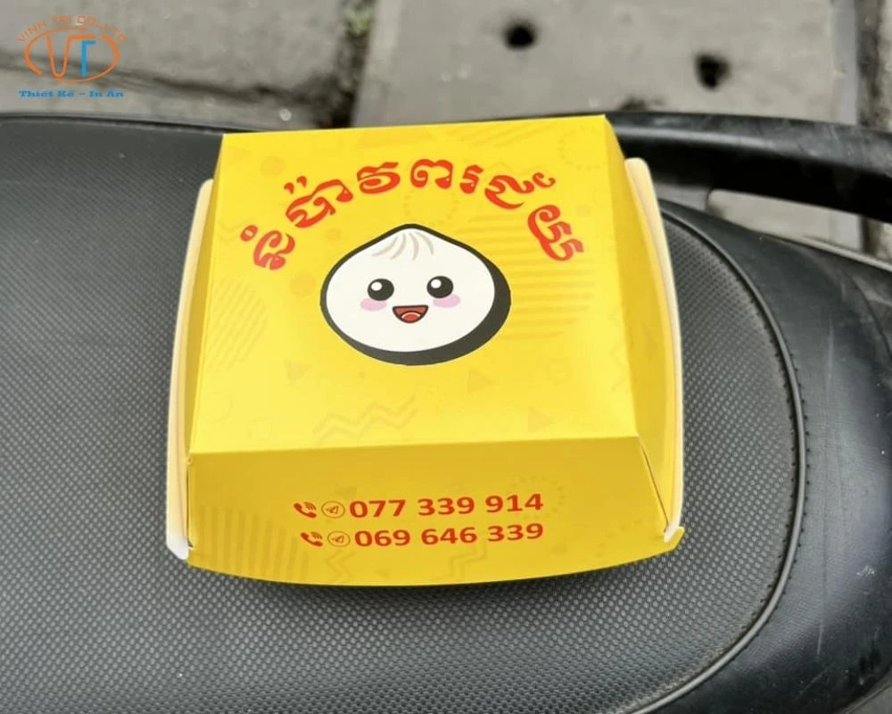 Hộp giấy đựng bánh bao màu vàng, có in hình bánh bao